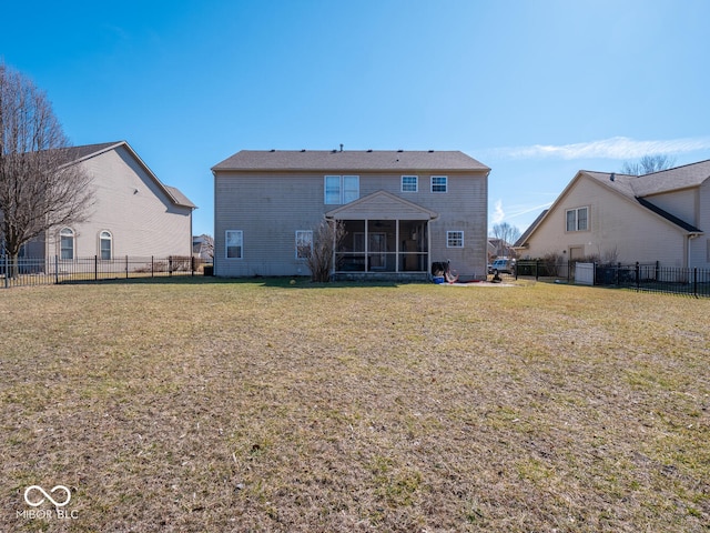 rear view of house with a sunroom, a fenced backyard, and a lawn