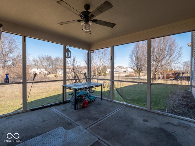 unfurnished sunroom featuring ceiling fan