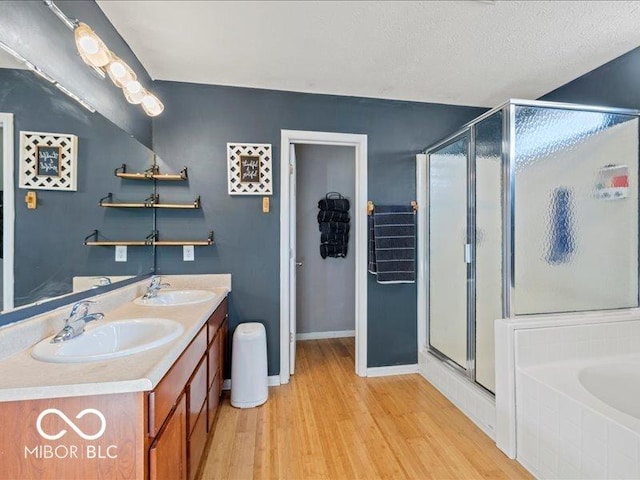 bathroom featuring a stall shower, wood finished floors, and a sink