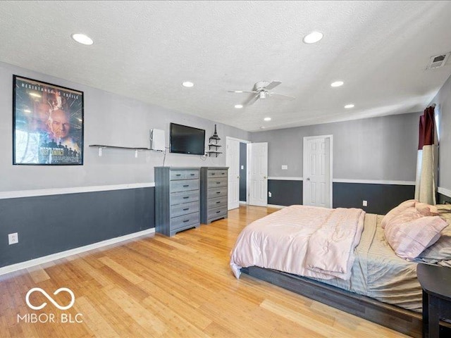 bedroom featuring recessed lighting, visible vents, light wood-style flooring, and a textured ceiling