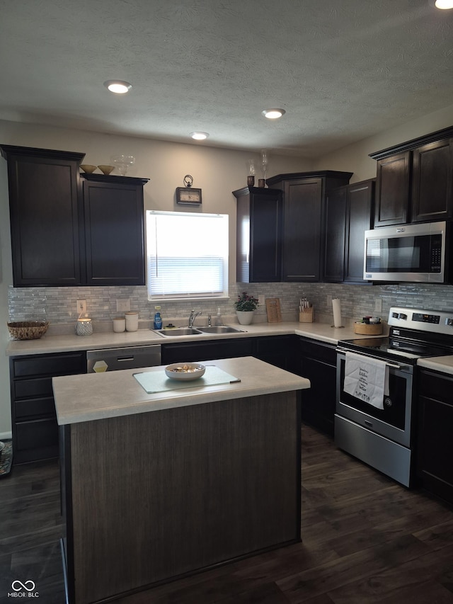 kitchen with dark wood-style flooring, appliances with stainless steel finishes, light countertops, and a sink