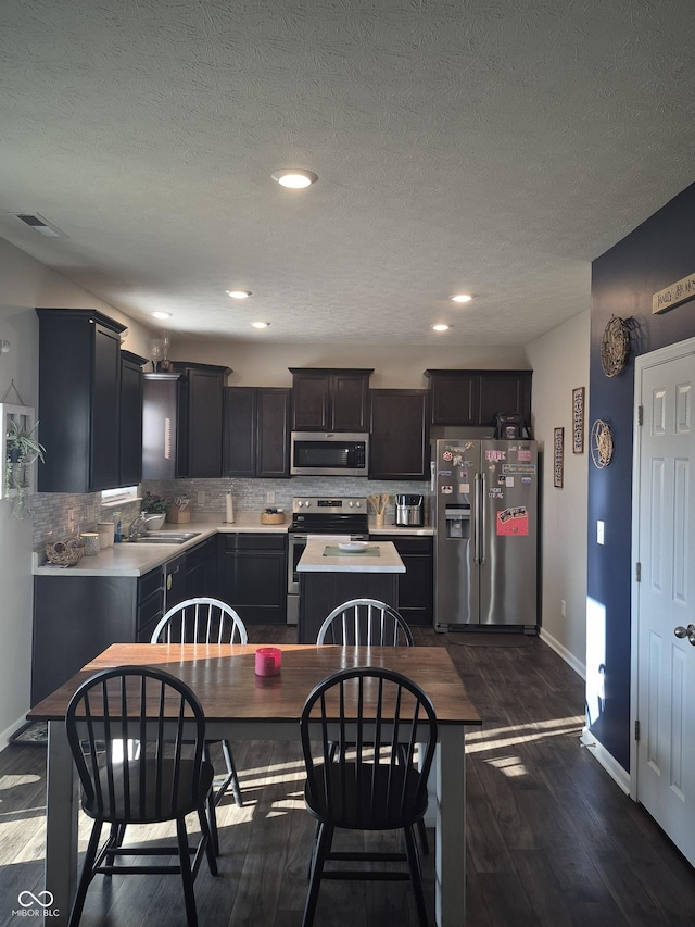 dining area with a textured ceiling, recessed lighting, visible vents, baseboards, and dark wood-style floors