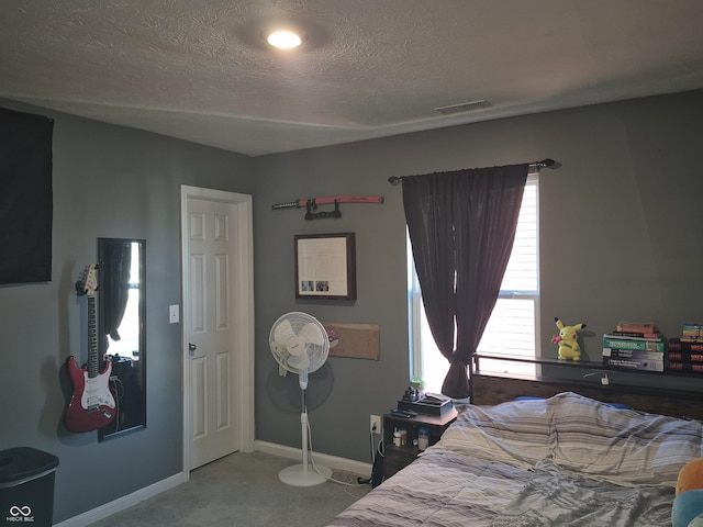 bedroom featuring baseboards, a textured ceiling, visible vents, and carpet flooring