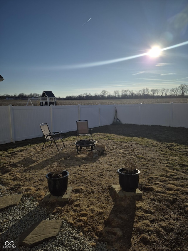 view of yard with a fenced backyard and a fire pit