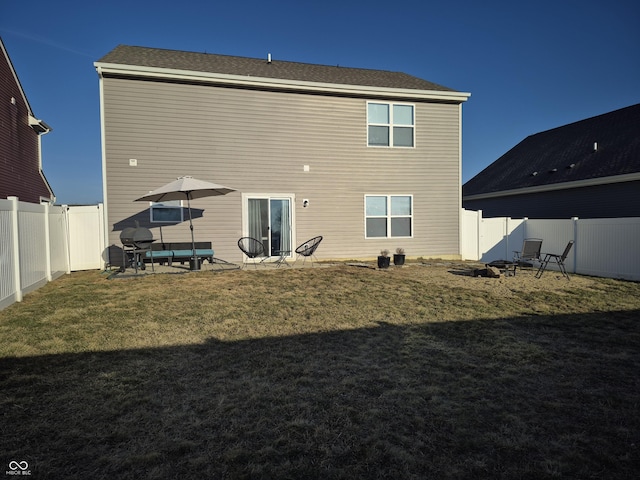 rear view of property with a yard and a fenced backyard