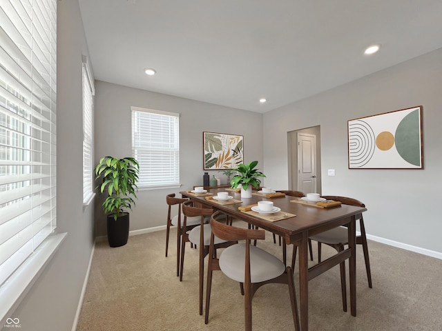 dining space featuring light carpet, baseboards, and recessed lighting