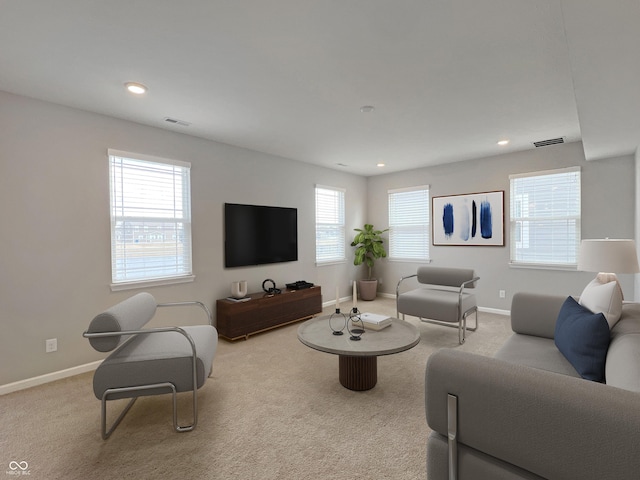 carpeted living room featuring baseboards, visible vents, and recessed lighting