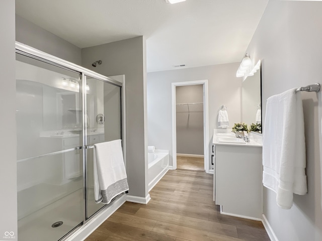 full bath featuring a stall shower, visible vents, vanity, and wood finished floors