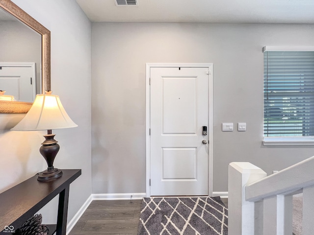 entrance foyer with dark wood-style floors, visible vents, and baseboards