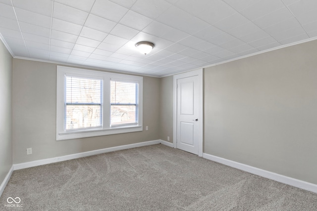 unfurnished room with baseboards, carpet, and ornamental molding