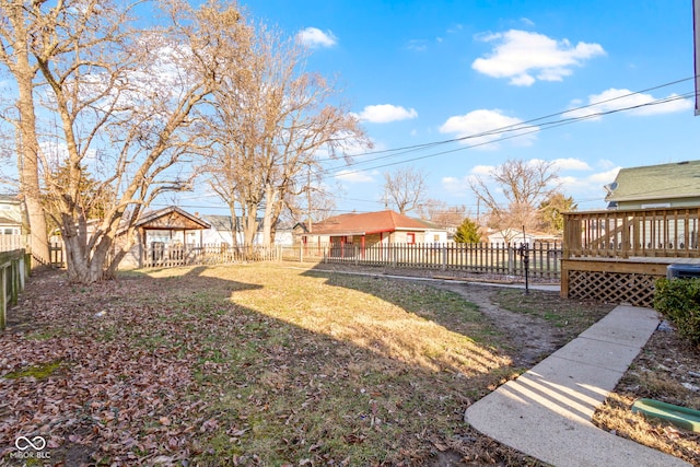 view of yard with a deck, an outdoor structure, and a fenced backyard