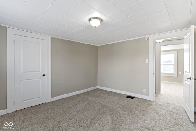 carpeted spare room featuring visible vents and baseboards