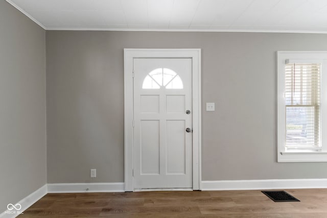 entryway with visible vents, ornamental molding, baseboards, and wood finished floors