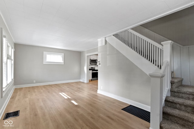 interior space with visible vents, baseboards, stairs, and light wood-style floors