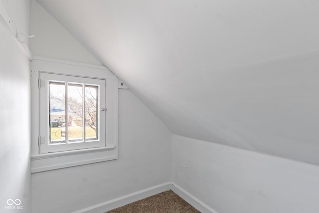 additional living space with carpet flooring, lofted ceiling, and baseboards