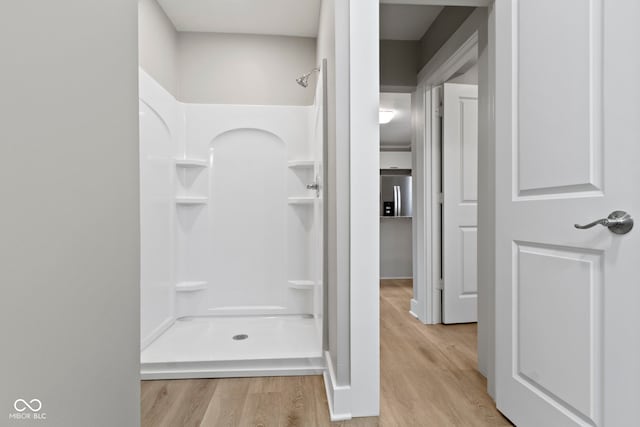 bathroom with a shower and wood finished floors