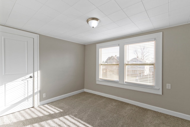 carpeted empty room with baseboards