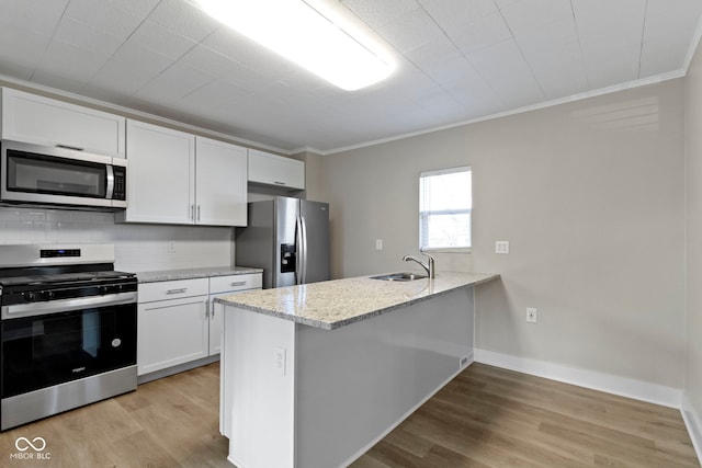 kitchen featuring appliances with stainless steel finishes, ornamental molding, white cabinets, and light wood finished floors