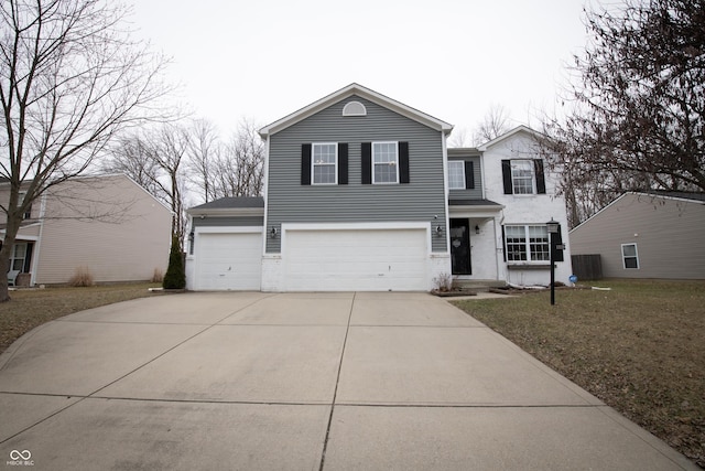 traditional-style house with a garage, central AC unit, concrete driveway, and a front yard