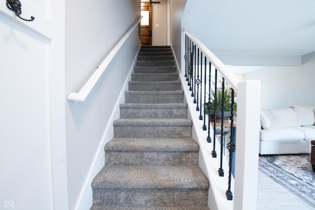 stairs with a barn door and wood finished floors