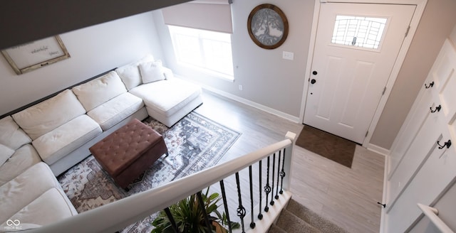 foyer entrance with stairs, baseboards, and wood finished floors