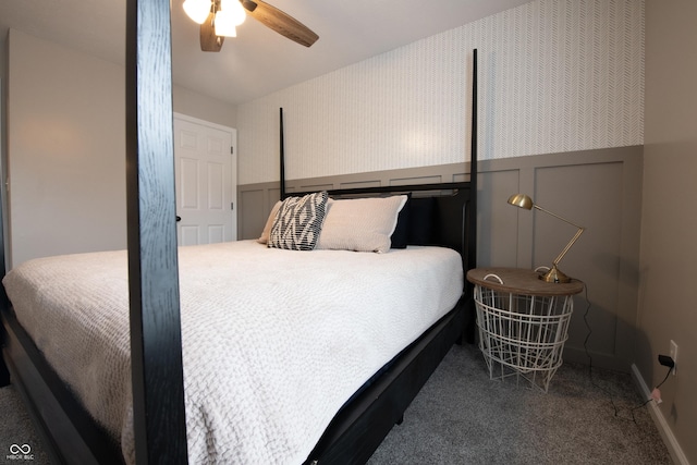 carpeted bedroom featuring ceiling fan, a decorative wall, wainscoting, and wallpapered walls