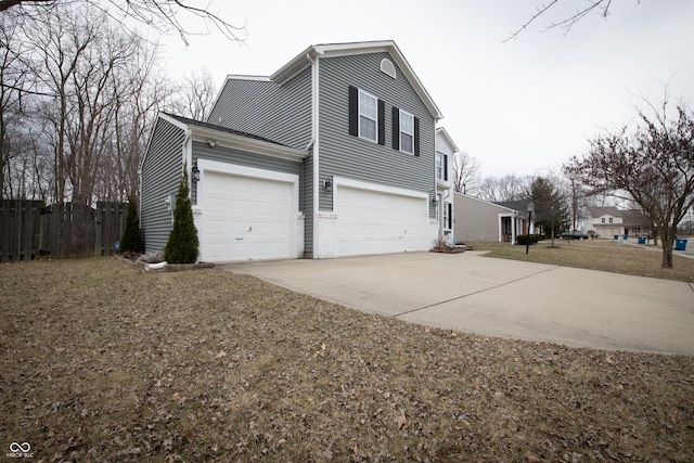 view of side of home with fence and concrete driveway