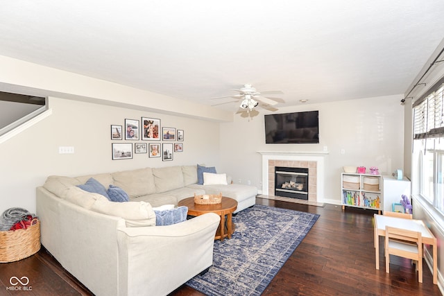 living room with ceiling fan, wood-type flooring, a fireplace, and baseboards