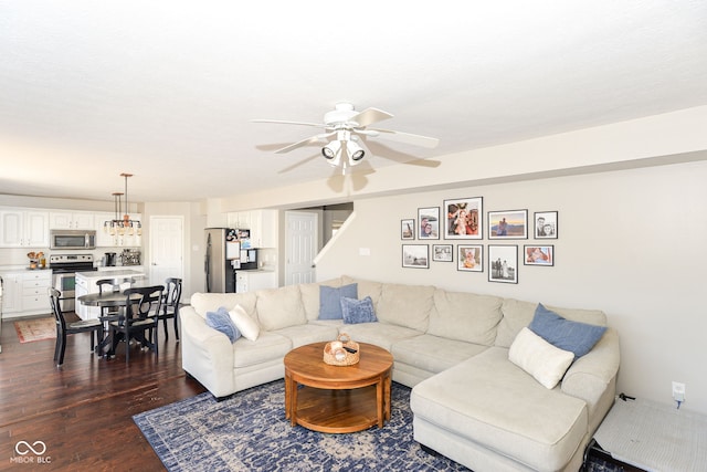 living room featuring stairs, a ceiling fan, and dark wood-type flooring