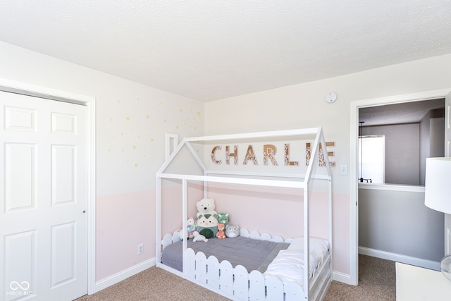 bedroom featuring a textured ceiling, carpet, and baseboards