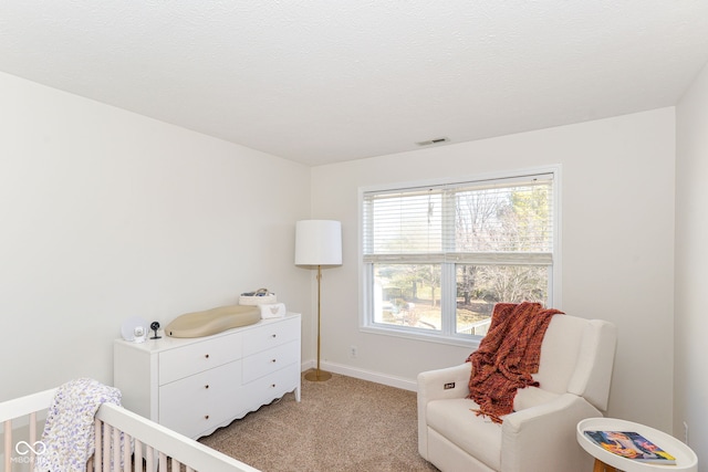 bedroom featuring light colored carpet, visible vents, a textured ceiling, and baseboards