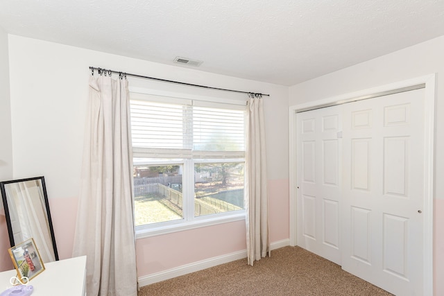 unfurnished bedroom with light carpet, multiple windows, visible vents, and baseboards