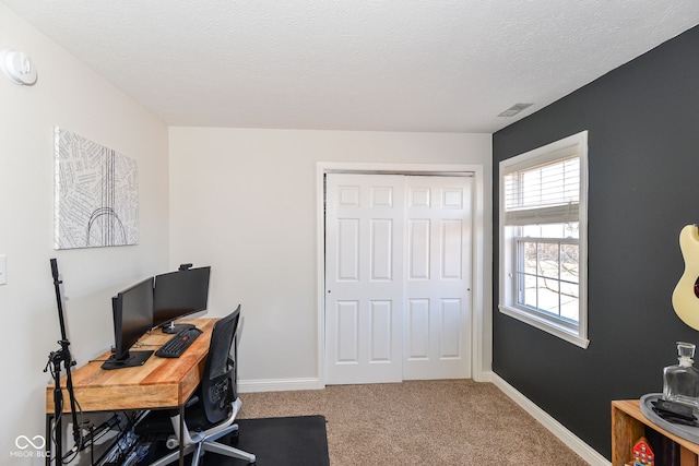 carpeted home office featuring a textured ceiling and baseboards