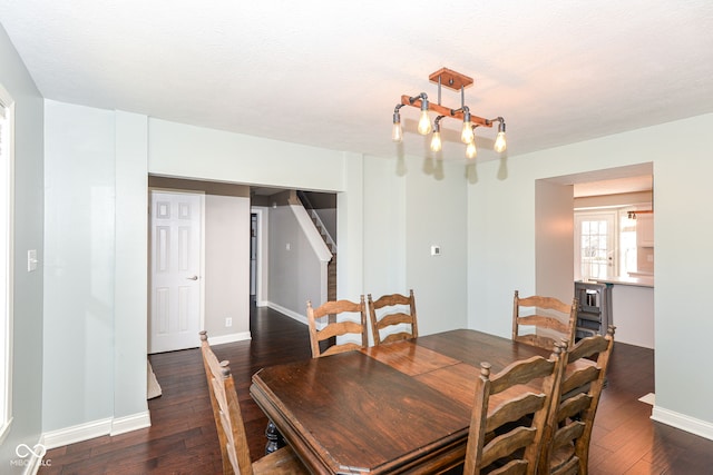 dining space featuring baseboards, a textured ceiling, and hardwood / wood-style floors