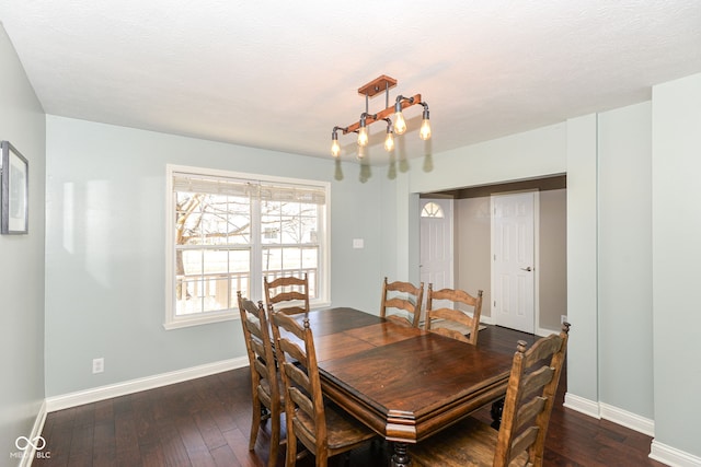 dining space featuring a textured ceiling, dark wood-type flooring, and baseboards