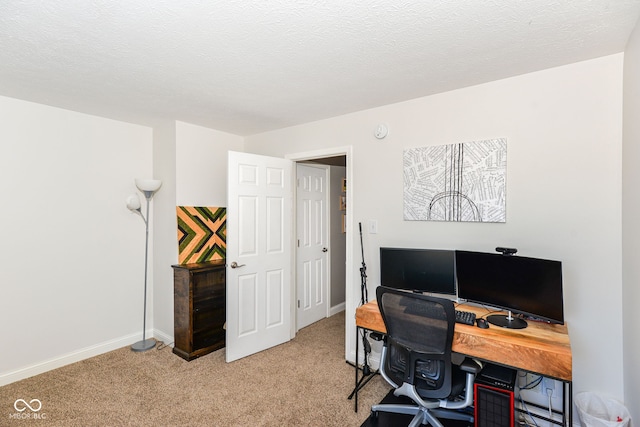 office space with light carpet, a textured ceiling, and baseboards