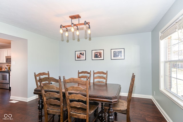 dining area with a healthy amount of sunlight, dark wood finished floors, and baseboards