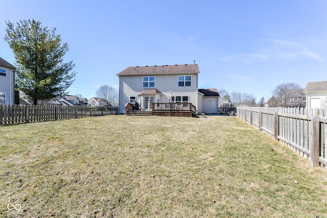 back of property featuring a fenced backyard, a deck, and a lawn