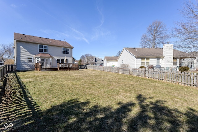 view of yard with a deck, french doors, and a fenced backyard