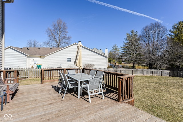 wooden terrace with fence, outdoor dining area, and a yard