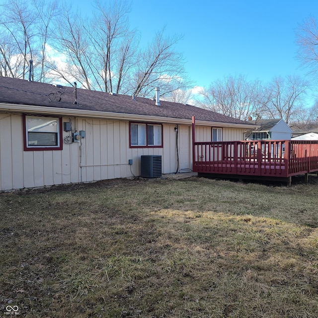 back of house with board and batten siding, central AC, a yard, and a wooden deck