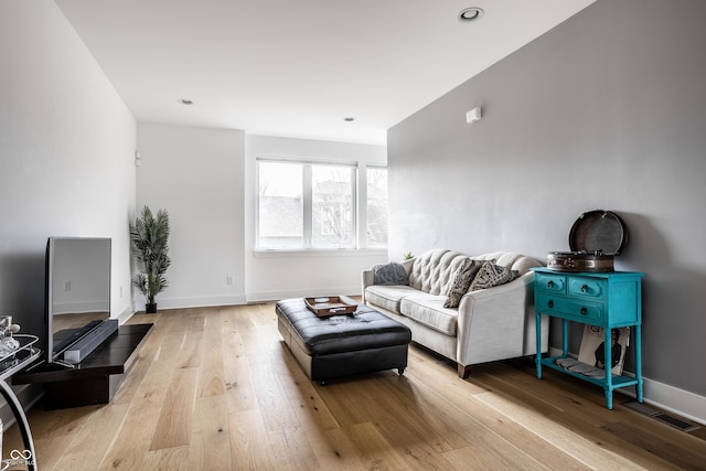 living room featuring visible vents, baseboards, hardwood / wood-style floors, and recessed lighting