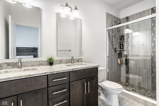 bathroom with a stall shower, a sink, and toilet