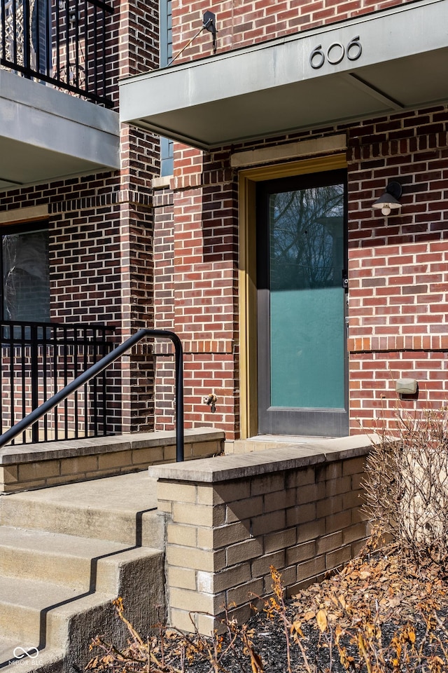 view of exterior entry with brick siding