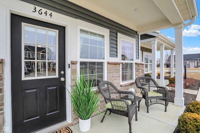 entrance to property with stone siding and a porch