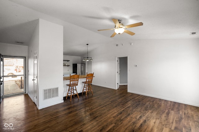 interior space featuring visible vents, vaulted ceiling, and wood finished floors