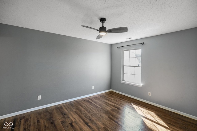 spare room with visible vents, baseboards, a ceiling fan, wood finished floors, and a textured ceiling