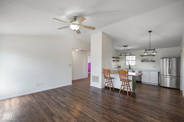 dining room with ceiling fan, lofted ceiling, visible vents, baseboards, and dark wood-style floors