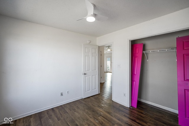 unfurnished bedroom featuring a textured ceiling, a closet, wood finished floors, and baseboards