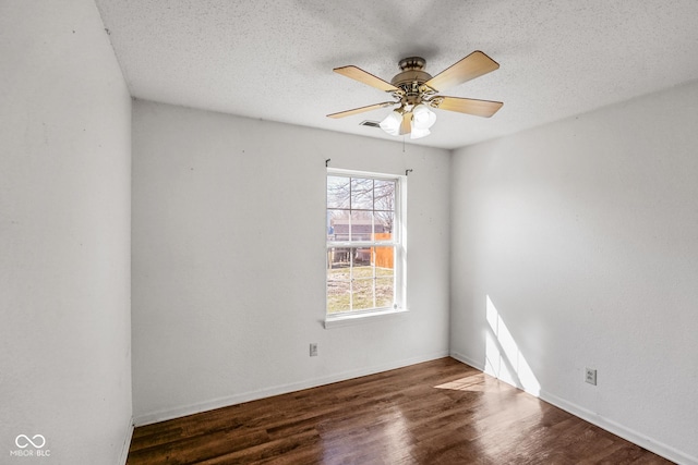 unfurnished room with ceiling fan, a textured ceiling, baseboards, and wood finished floors